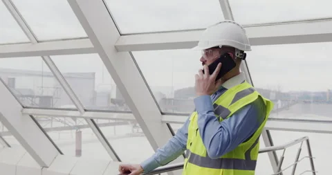 Male builder engineer in hardhat and vest standing inside commercial building Stock-Footage 153169544