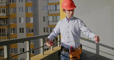Male builder examines tools to start process checking tape Stock Footage 228032714