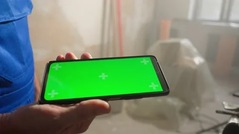 Male builder holding touch screen smartphone with green screen chroma key. Man 스톡 동영상 227576989