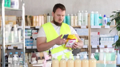 Male builder scans code on package of paracetamol pills to check the expiration Stock Footage 341427288