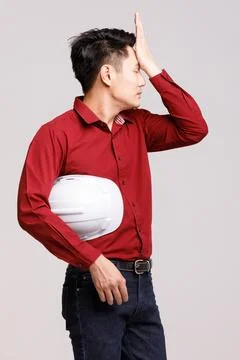 Male builder touching head in studio Stock Photos