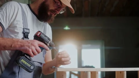 Male builder using electrical screwdriver to connect two wooden pieces in studio Stock Footage 170502113