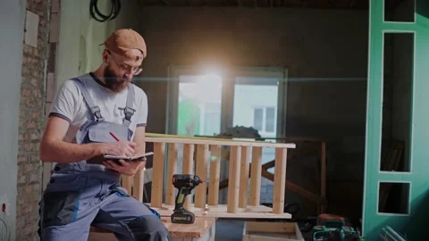 Male builder writes down measurements of construction in a notebook Video stock 170502597