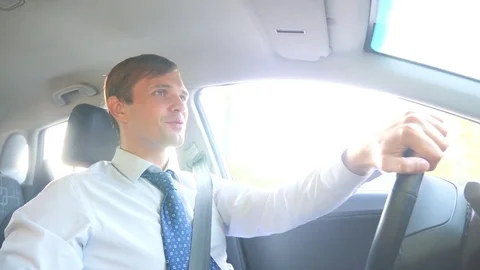 A male businessman in a shirt and tie talks to the passenger, distracted from Stock Footage