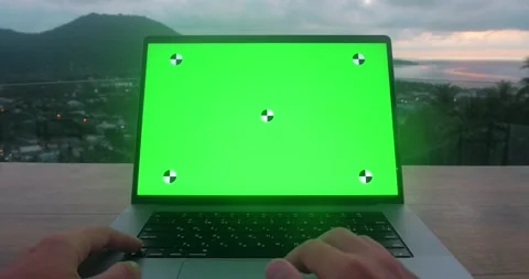 Male businessman using computer with green screen while sitting on rooftop on Stock Footage 238536335