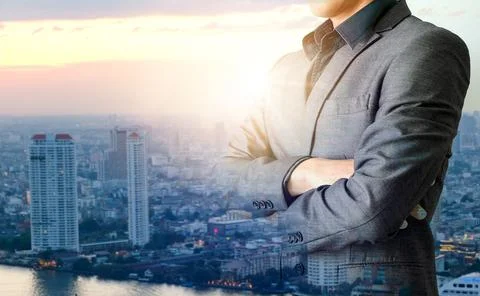 Male businessmen stand the background of a growing business city. Stock Photos