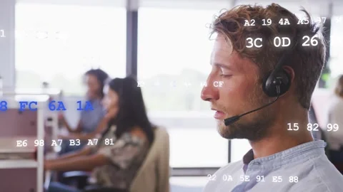 Male call center agent taking call speaking into headset team typing hex codes Stock Footage 333595002