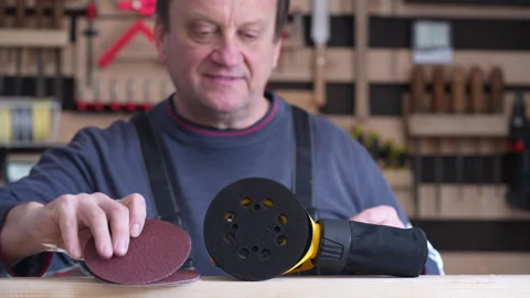 Male carpenter in carpentry workshop fixing an sandpaper on orbital wood sand Видео 331537178