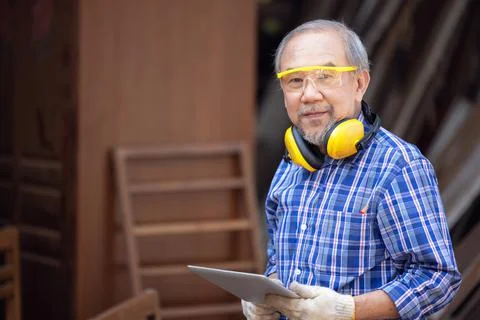 Male carpenter in a construction workshop, using a digital tablet Stock Photos