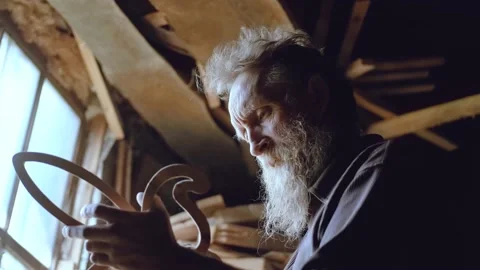 Male carpenter with a gray beard, processes a wood product before painting. An Stock Footage 133064734