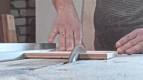 A male carpenter saws boards with a circular saw in the workshop Stock Footage 242908972