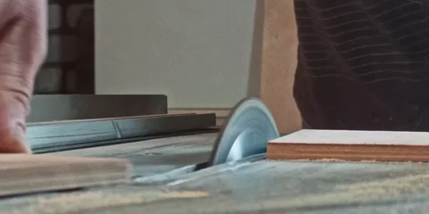 A male carpenter saws boards with a circular saw in the workshop Stock Footage 242909082
