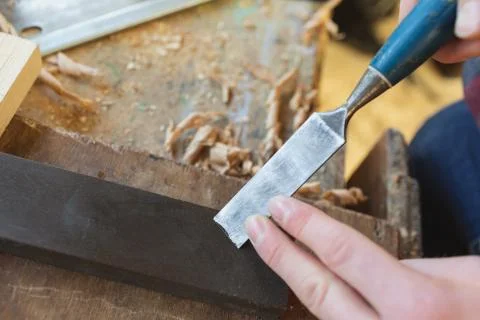 Male carpenter sharping chisel in workshop Stock Photos