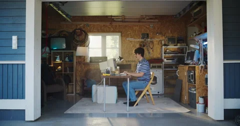 Male Caucasian Programmer Using Computer In Retro Garage Stock Footage 255996579