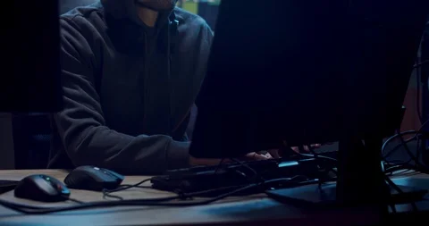 Male Caucasian software developer and programmer in a hood working at night at Stock Footage 124337609
