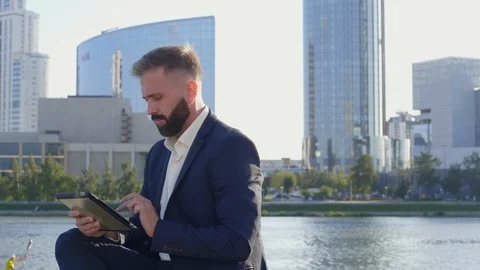 Male CEO working on tablet computer on river promenade Stock Footage 120665962