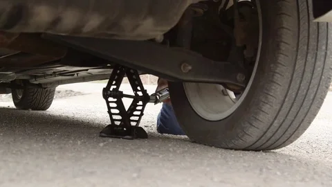 Male Changing Flat Tire On Side Of Road with Car Jack Vídeo Stock 74882357