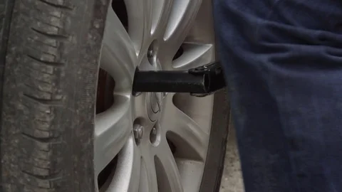 Male Changing Flat Tire On Side Of Road - Loosening Lugnuts 動画素材 74903393