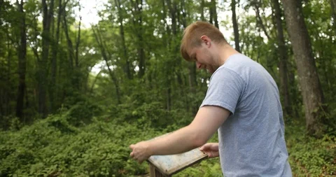 Male checking / fixing trail map Stock Footage 112583480