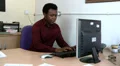 Male checks paperwork against computer HD Footage