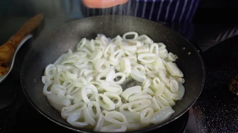 Male chef adding salt into fried squid ring in a pan calamari spice, 4K top view Stock Footage 156115369