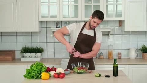 Male chef adding spices to vegan salad while standing in kitchen at home Stock Footage 151401677