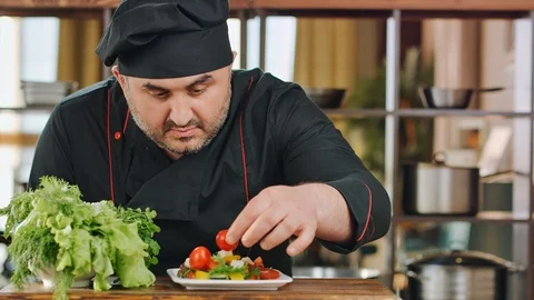 Male chef adding tomato decorating vegetable salad. Medium close up shot on 4k Video stock 124155046
