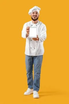 Male chef with blank tablet computer on yellow background Stock Photos