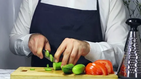 Male chef chops cucumber 스톡 동영상 182555706