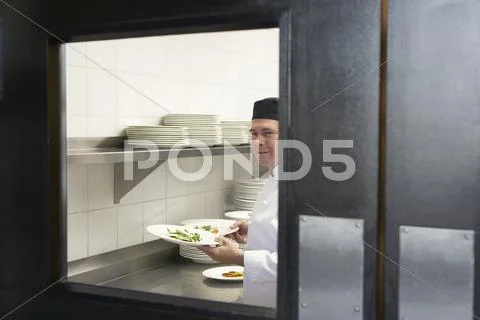 Male Chef With Food Plates In Kitchen Stock Photos