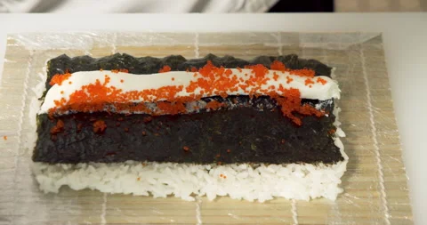 Male chef hands preparing delicious sushi rolls with cheese, tuna and tobiko Stock Footage 135594433