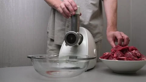 A male chef makes ground beef in an electric meat grinder. Close-up. Slow motion Stock Footage 170607872