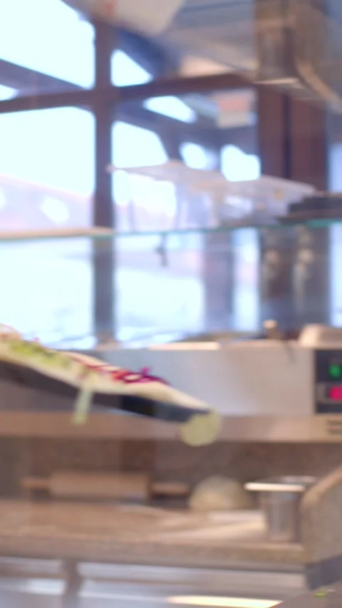 Male chef plating a composed dish behind glass in warm restaurant kitchen Stock Footage 336534915