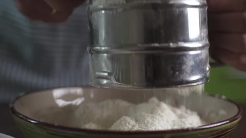 A male chef in the process of sifting white wheat flour with a sieve Stock Footage 278439789