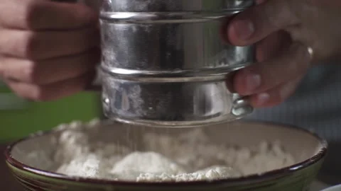 A male chef in the process of sifting white wheat flour with a sieve Stock Footage 278439818
