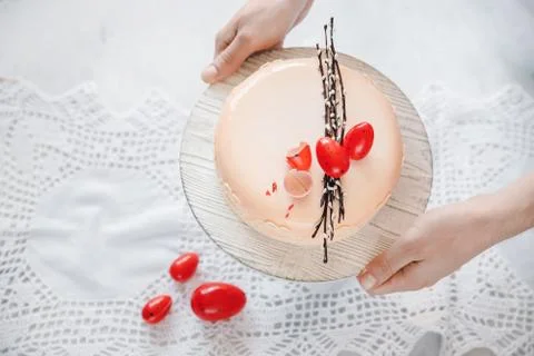 Male chef puts Easter cake kulich with chocolate eggs and willow on table. Top Stock Photos