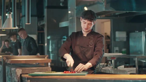 Male chef is smiling while chopping vegetables Stock Footage 158164324