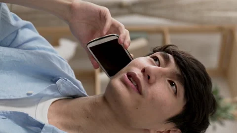 Male chuckling while chatting on the cell phone Video stock 219397639
