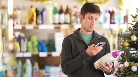 Male client choose and scanning QR code on package liquid detergent Vídeo Stock 344776028