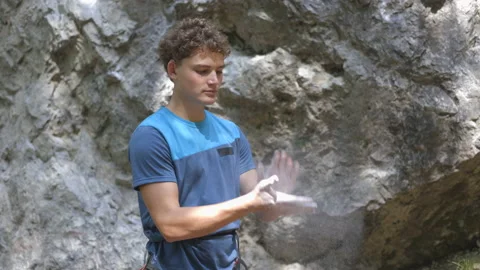 Male climber clapping hands to remove magnesium dust Stock Footage 208936846