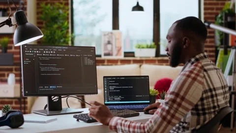 Male coder works from home typing code on a laptop in a modern living room 스톡 동영상 319713259