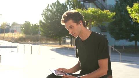Male college student using digital tablet for video call at campus on sunny day Stock Footage 136981781