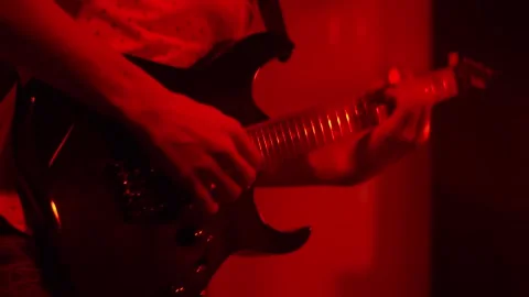 The male composer plays a six-string electric guitar and loudly. Performing an Stock Footage 144922124