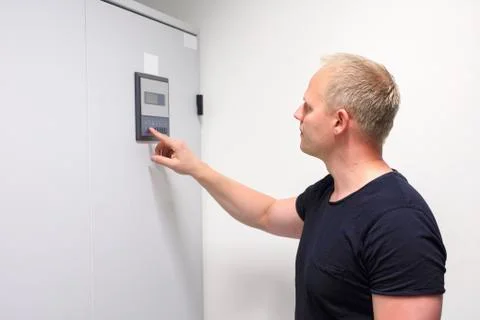Male Computer Engineer Adjusting Air Conditioner In Datacenter Stock Photos