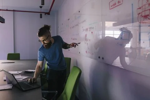 Male computer programmer brainstorming in conference room Stockfoto's