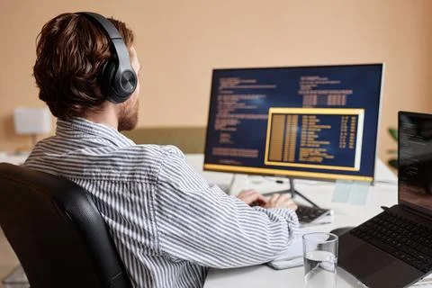 Male Computer Programmer Coding and Wearing Headphones Stock Photos