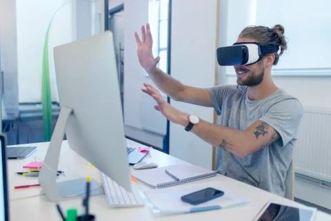 Male computer programmer programming virtual reality simulator glasses at 스톡 사진