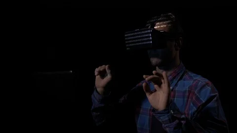Male computer programmer sitting at desk and wearing virtual reality helmet t Stock Footage 86434515