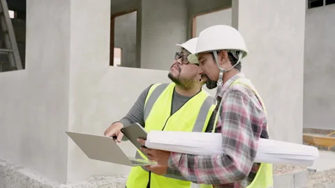 Male construction engineer is giving advice male junior who is working Stock Footage 265252273