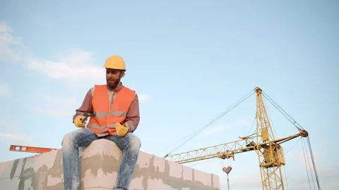 Male construction worker considers plans while overseeing site Stock Footage 295960535